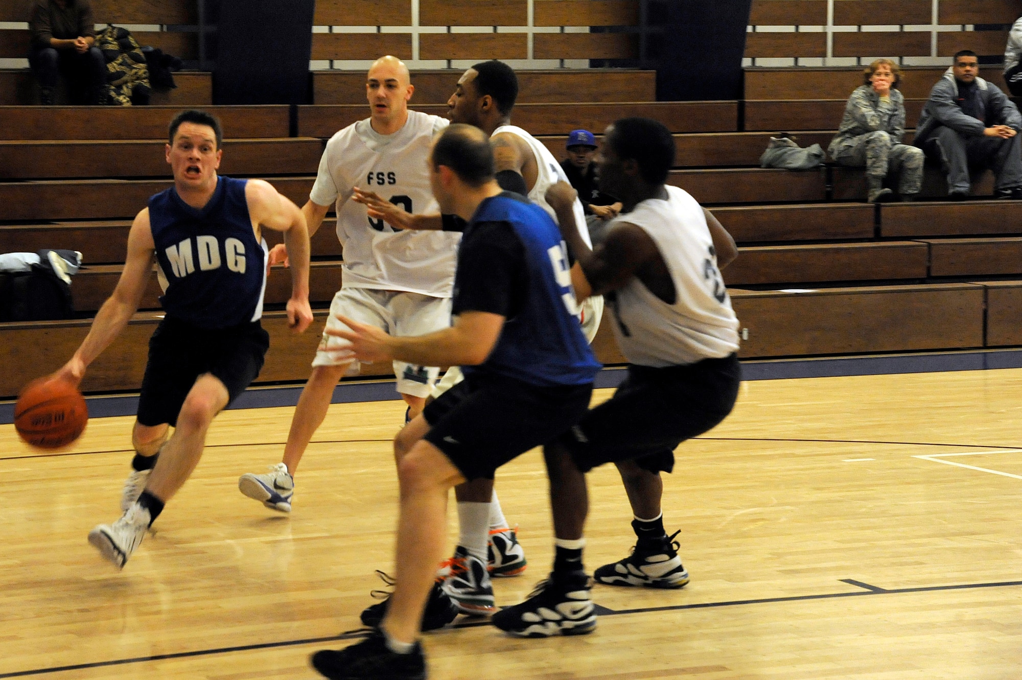 MISAWA AIR BASE, Japan - Cole Taylor, left, 35th Medical Group team member, dribbles the ball around members of the Misawa Security Operations Center during the base intramural basketball championship game held at the Potter Fitness Center here, Jan. 11. The 35 MDG won the first game of the double elimination tournament 36-39 forcing the MSOC to win the second game in order to take the base championship. (U.S. Air Force photo/Tech. Sgt. Marie Brown)
