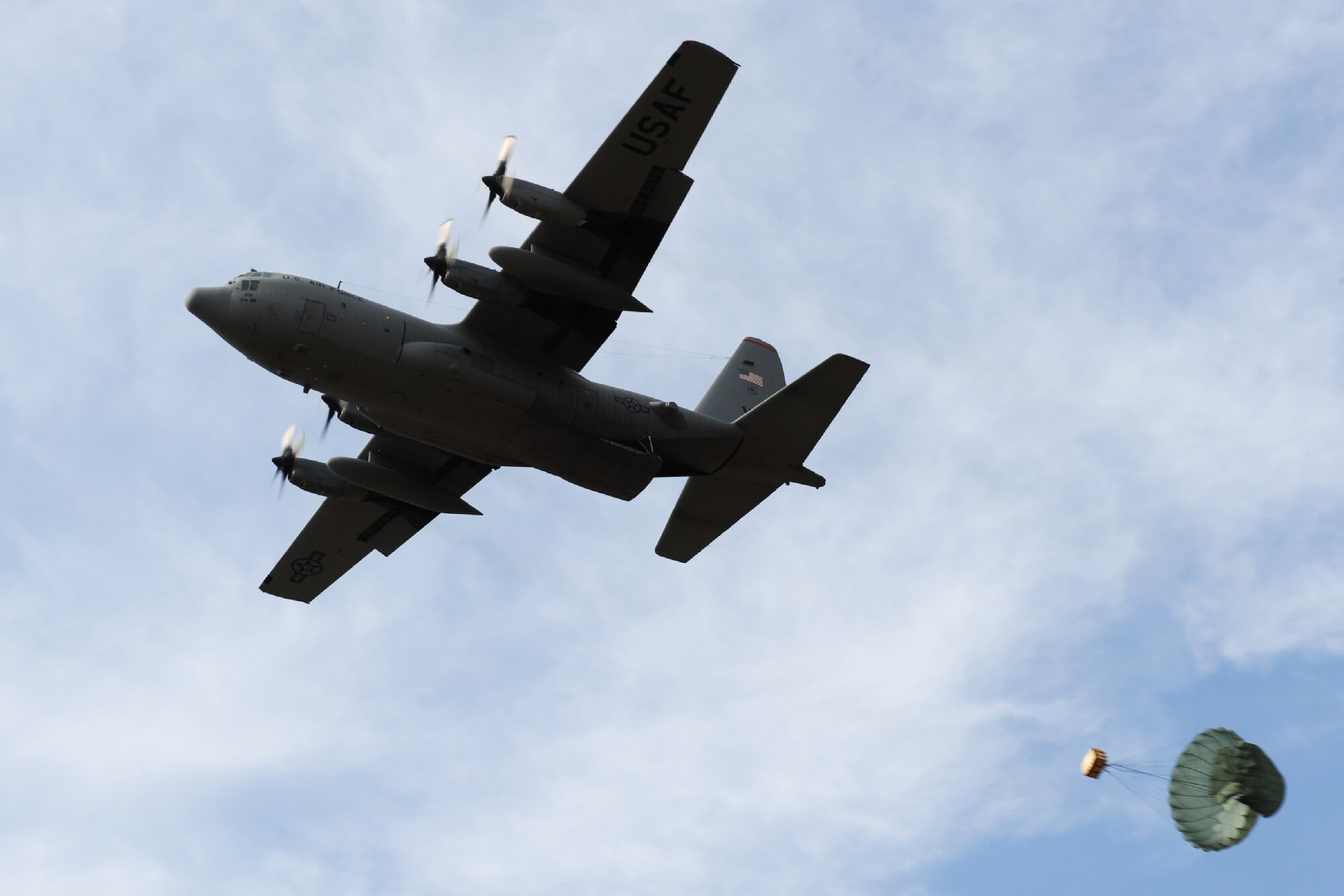 YOKOTA AIR BASE, Japan -- A C-130 Hercules aircraft with the 36th Airlift Squadron performs a low-cost, low-altitude cargo airdrop over Yokota Air Base, Japan, Jan. 10, 2012. Aircrews from the 36th AS regularly conduct LCLA training missions to ensure their readiness to support operational missions in the Pacific region and around the world. (U.S. Air Force photo/Capt. Raymond Geoffroy)