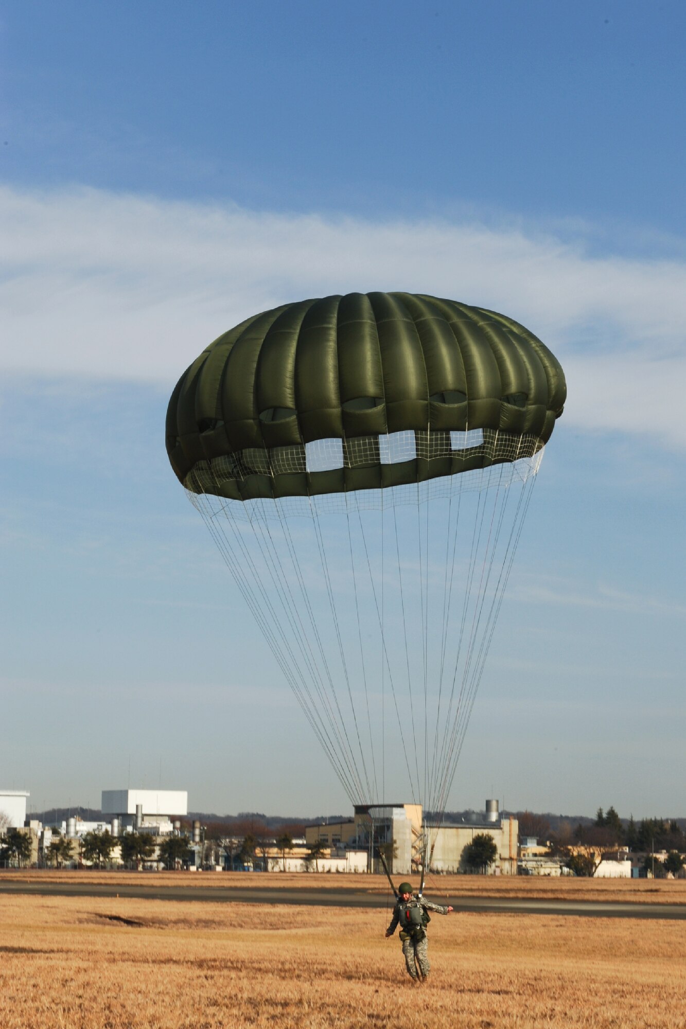 YOKOTA AIR BASE, Japan -- A U.S. Army paratrooper descends onto the airfield at Yokota Air Base, Japan, Jan. 10, 2012. Yokota hosted parachute training during a Samurai Surge formation flight performed by the 36th Airlift Squadron. (U.S. Air Force photo/Capt. Raymond Geoffroy)