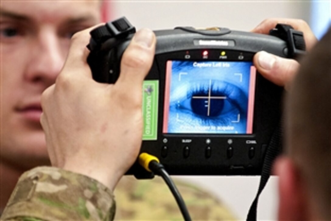 A paratrooper scans the iris of a soldier using a Handheld Interagency Identity Detection Equipment, or HIIDE, system during training at the Joint Readiness Training Center on Fort Polk, La., Jan. 10, 2012.