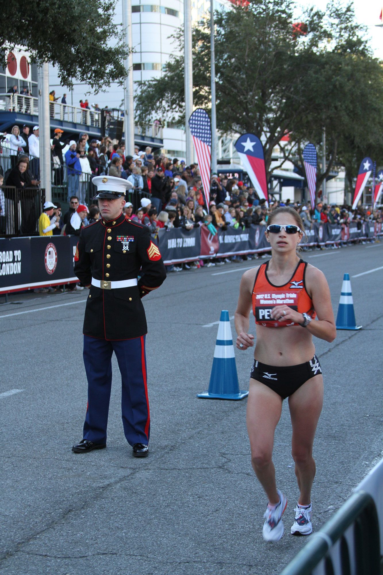 Sergeant Joseph M. Pearson, an operations clerk with RS Houston, Texas, and a Houston native, stands at the finish line during the 2012 Olympic Trials Marathon, Jan. 14, in Houston, as an athlete runs by.