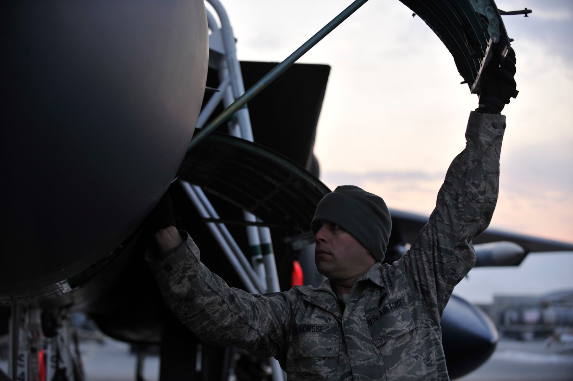 BAGRAM AIRFIELD, Afghanistan—Staff Sgt. Ryan Forsse opens a hatch on F-15E Strike Eagle #89-0487 in order to perform pre-flight maintenance on the aircraft before it goes on the mission that will bring its logged flying hours up to 10,000 at Bagram Airfield, Afghanistan, Jan. 13, 2012. Forsse is a crew chief with the 455th Expeditionary Aircraft Maintenance Squadron and is deployed from Seymour-Johnson Air Force Base, N.C. (U.S. Air Force photo/ Airman 1st Class Ericka Engblom)