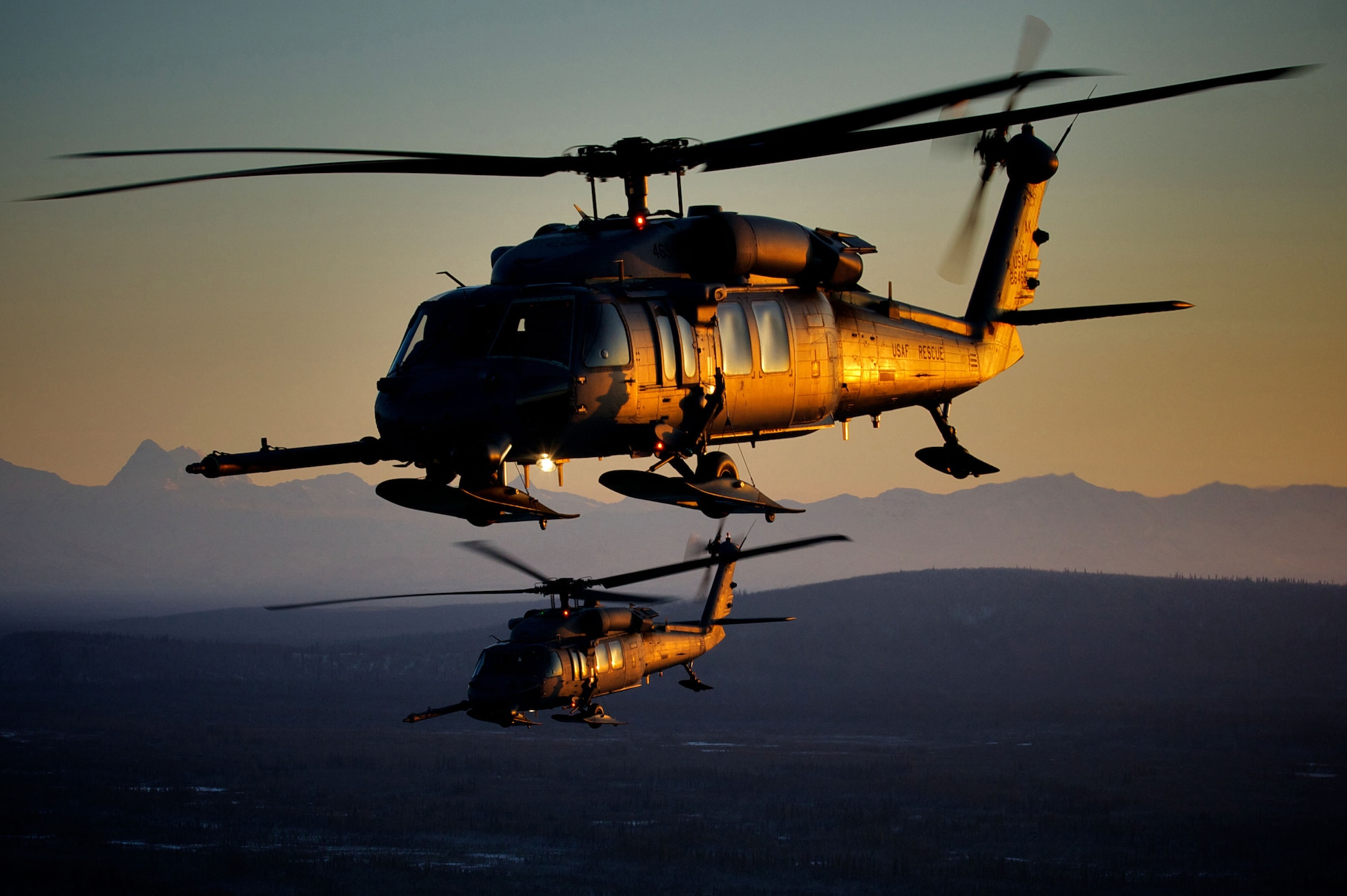 A pair of 210th Rescue Squadron HH-60 Pave Hawk helicopters fly over Alaska on a training mission. (Photo by Master Sgt. Sean Mitchell, 210th Rescue Squadron, Alaska Air National Guard)


