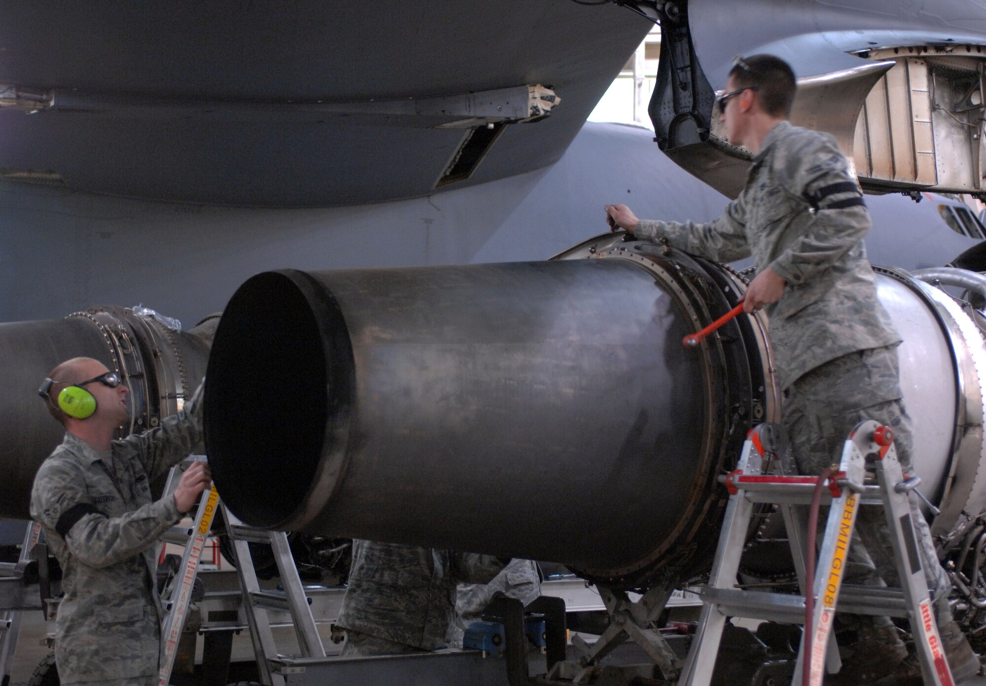 Airmen 1st Class Corey Cutright and Hugo Zueger-Garcia, both from the 2nd Maintenance Squadron, remove the exhaust nozzle on a B-52H Stratofortress on Barksdale Air Force Base, La., Jan. 12. Cutright and Zueger-Garcia work together to check for any broken or loose parts under the exhaust nozzle. (U.S. Air Force photo/Airman 1st Class Joseph A. Pagán Jr.)(RELEASED)
