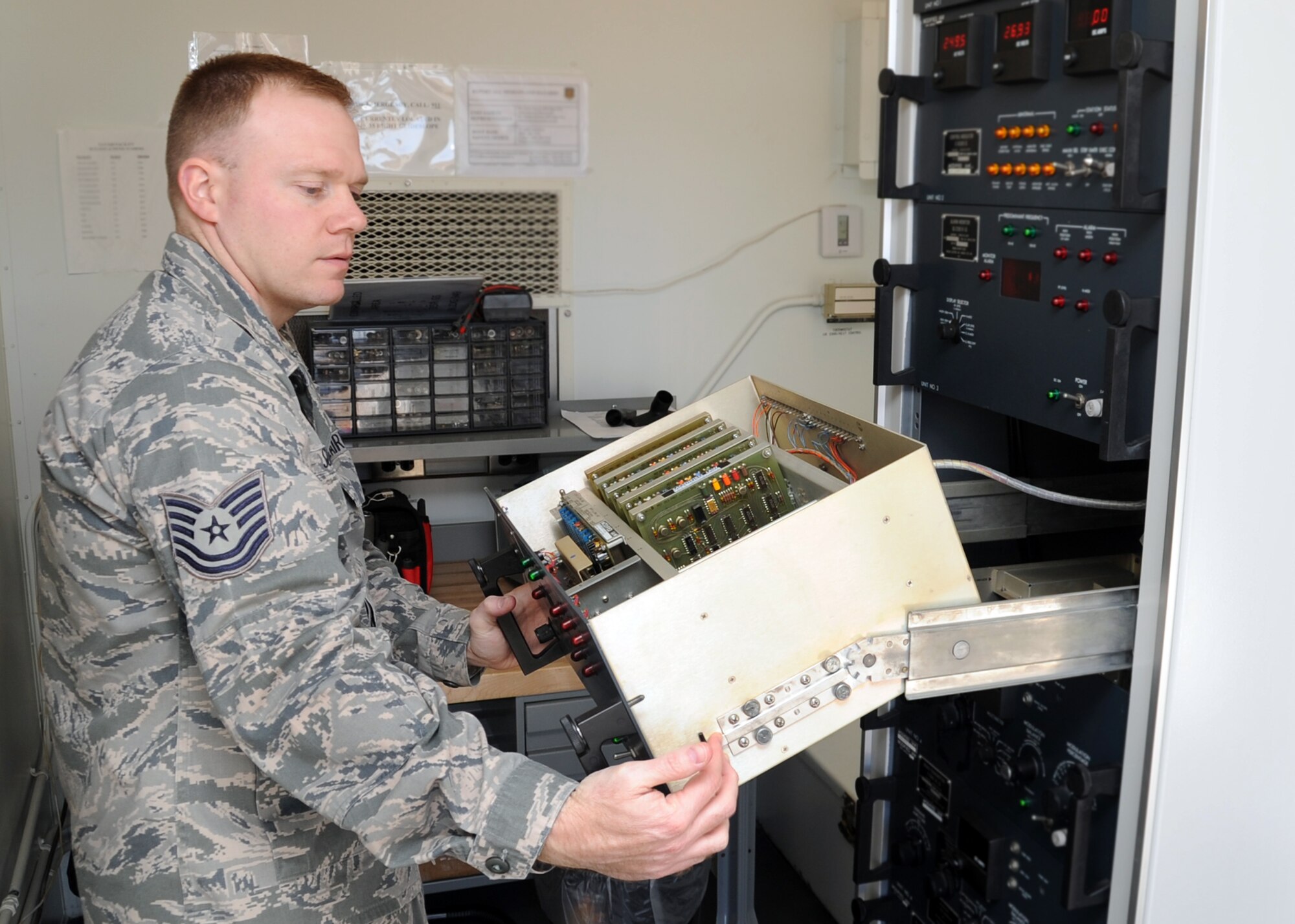 ALTUS AIR FORCE BASE, Okla. – Tech. Sgt. Brandon Sutliff, 97th Communications Squadron, NCO in charge of airfield systems, opens the inside of an instrument landing system at the 35 right airfield, Jan. 13, 2011. An ILS transmits, monitors and distributes frequencies to antennas on the airfield that travels to the aircraft, helping pilots land during inclement weather. (U.S. Air Force photo by Airman 1st Class Franklin Ramos / 97th Air Mobility Wing Public Affairs / Released) 