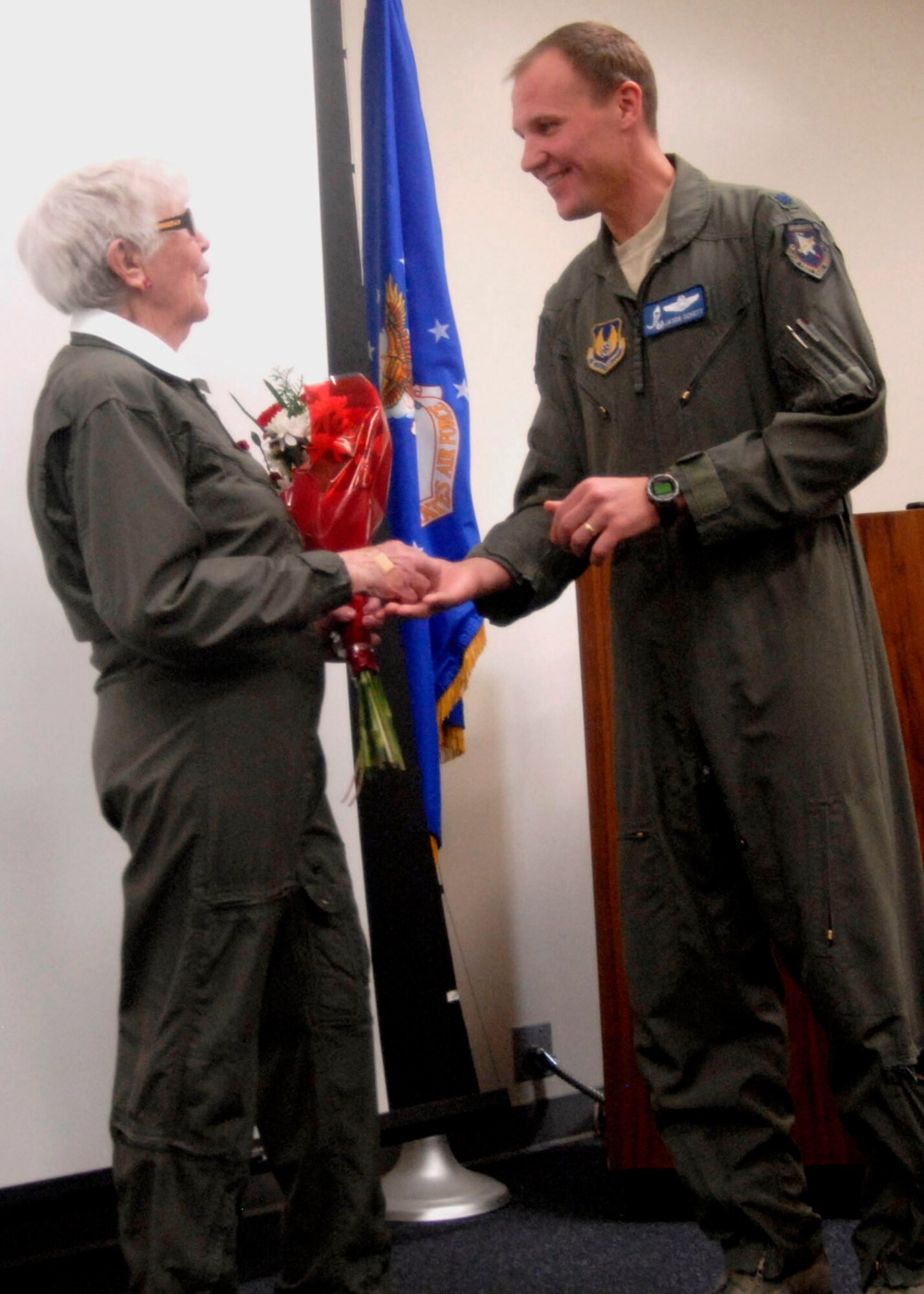 Lt. Col. Jason Schott presents Flora Belle Reece with flowers and a commander's coin to thank her for sharing her stories about faith, family, and flying with the 445th Flight Test Squadron. (U.S. Air Force Photo by Laura Mowry)