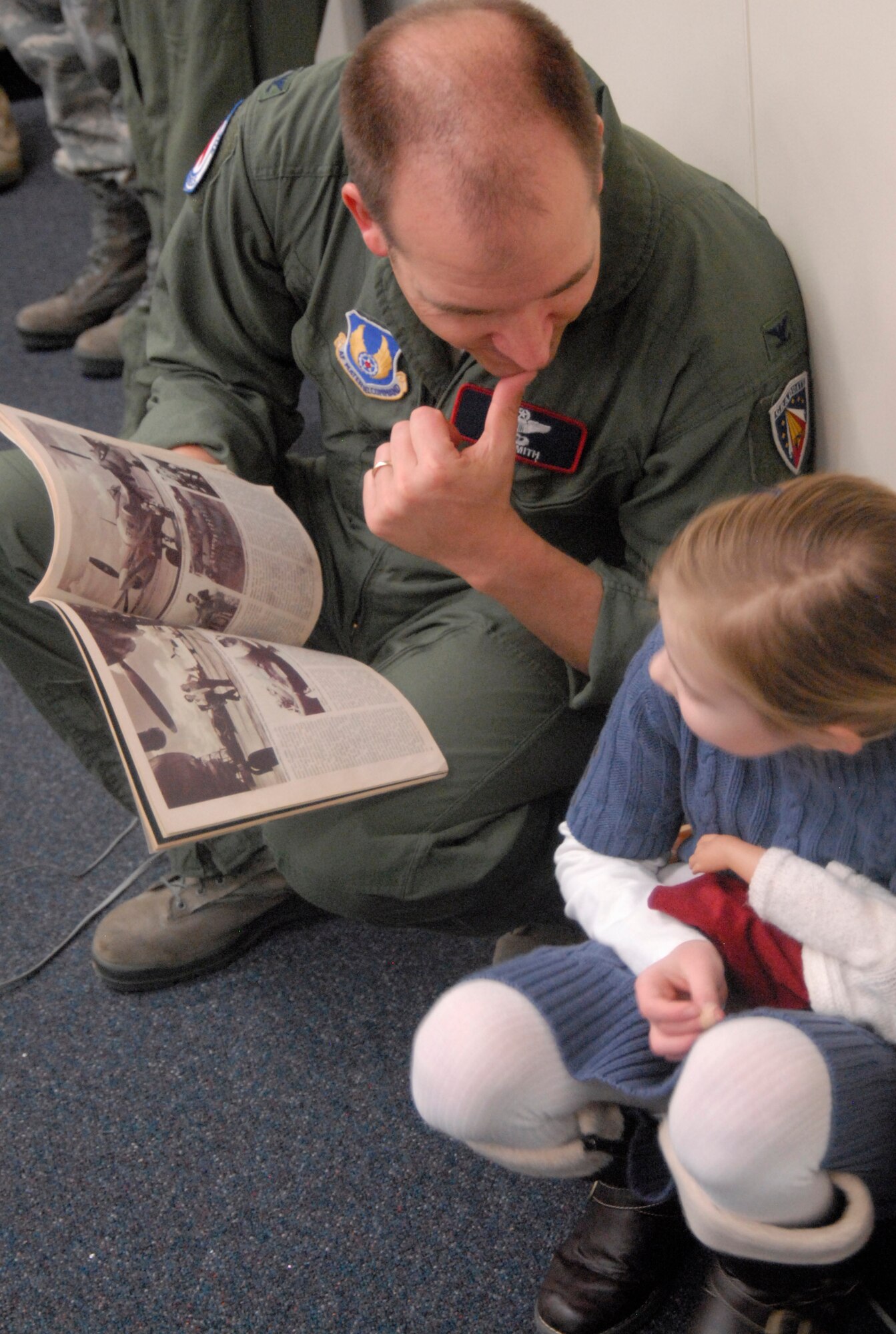 Col. Ryan J. Smith, vice commander, 412th Test Wing, talks with his daughter about the 1977 issue of "Viva" magazine featuring an article about Flora Belle Reece and her accomplishments as a Women's Airforce Service Pilot. (U.S. Air Force Photo by Laura Mowry)