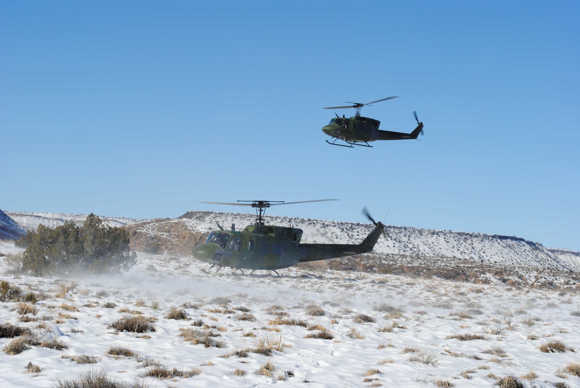 A UH-1N assigned to the 512th Rescue Squadron lands while another hovers overhead Dec. 27. U.S. Air Force Photo by John Cochran.