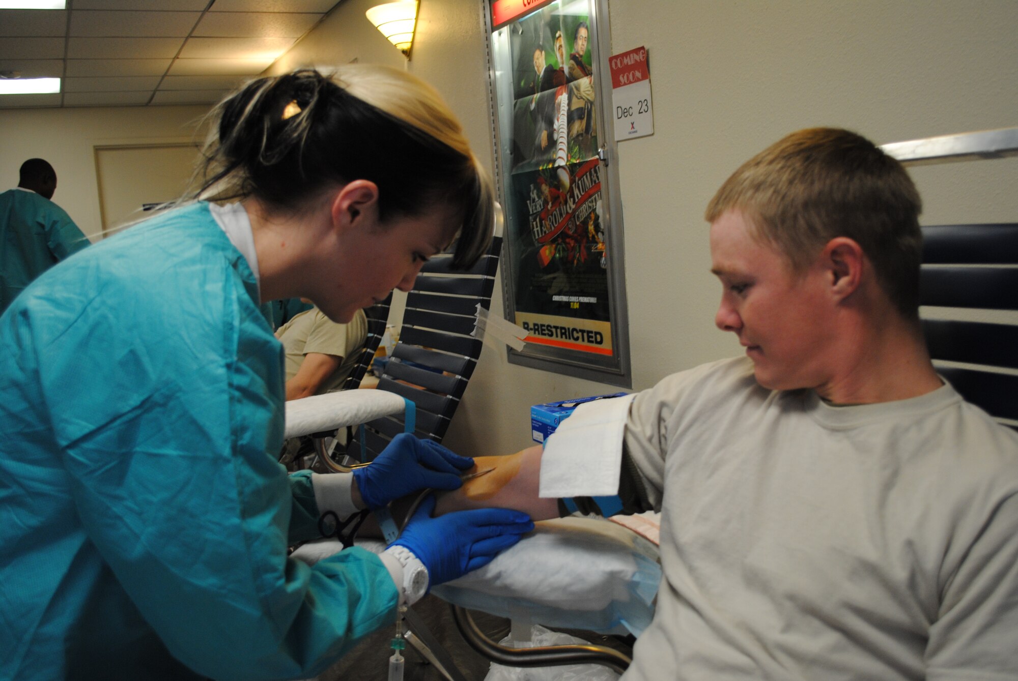 Elisa Lombardo, Armed Services Blood Program medical technician, left, draws blood from Senior Airman John Thompson, 377th Security Forces Squadron, at the base theater Dec. 13.  Photo by Jonathan Rejent