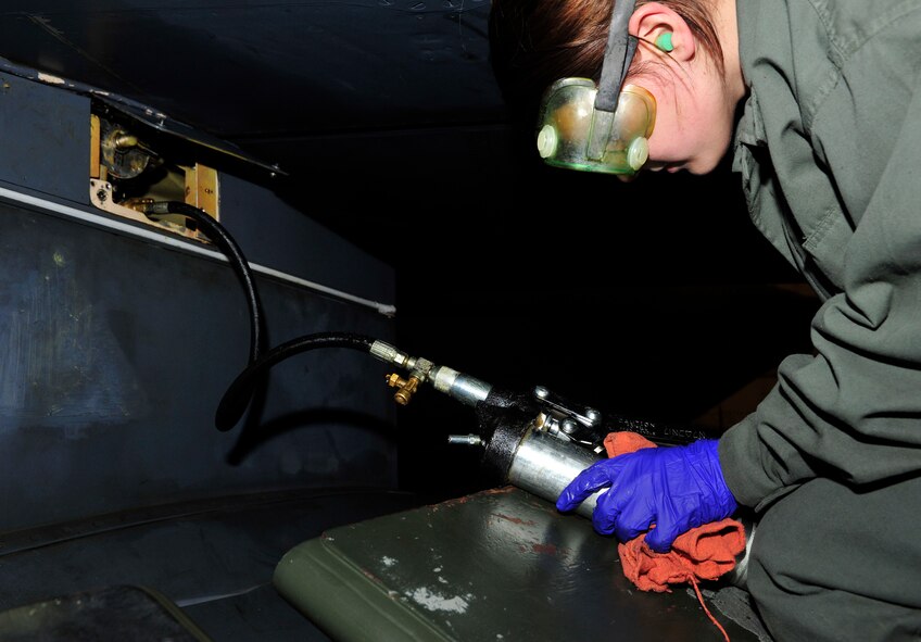 MINOT AIR FORCE BASE, N.D -- Airman Alyssa Mills, 5th Aircraft Maintenance Squadron aircraft weapon armament apprentice, uses a pump to release the pylon on a B-52H Stratofortress during a munitions download operation here Jan. 11. Munitions downloads are performed monthly to ensure proficiency and certification of weapon specialists. (U.S. Air Force photo/Senior Airman Desiree W. Esposito)