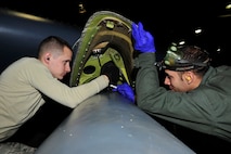 MINOT AIR FORCE BASE, N.D -- Staff Sgts. Christopher West and Jesus Virola Martinez, 5th Aircraft Maintenance Squadron aircraft weapon armament specialists, remove bolts holding the buffet fairing on a B-52H Stratofortress during a munitions download operation here Jan. 11. Munitions downloads are performed monthly to ensure proficiency and certification of weapon specialists. (U.S. Air Force photo/Senior Airman Desiree W. Esposito)