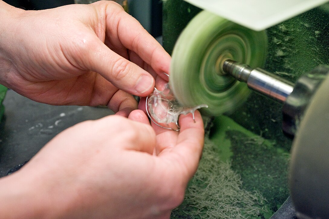 Lt. Col. Philip Junghans, 779th Dental Squadron flight commander, uses a lathe to polish a bite plate appliance in the Andrews dental laboratory Jan. 10. The bite plate is used to protect teeth from night time grinding. (Photo /Bobby Jones)