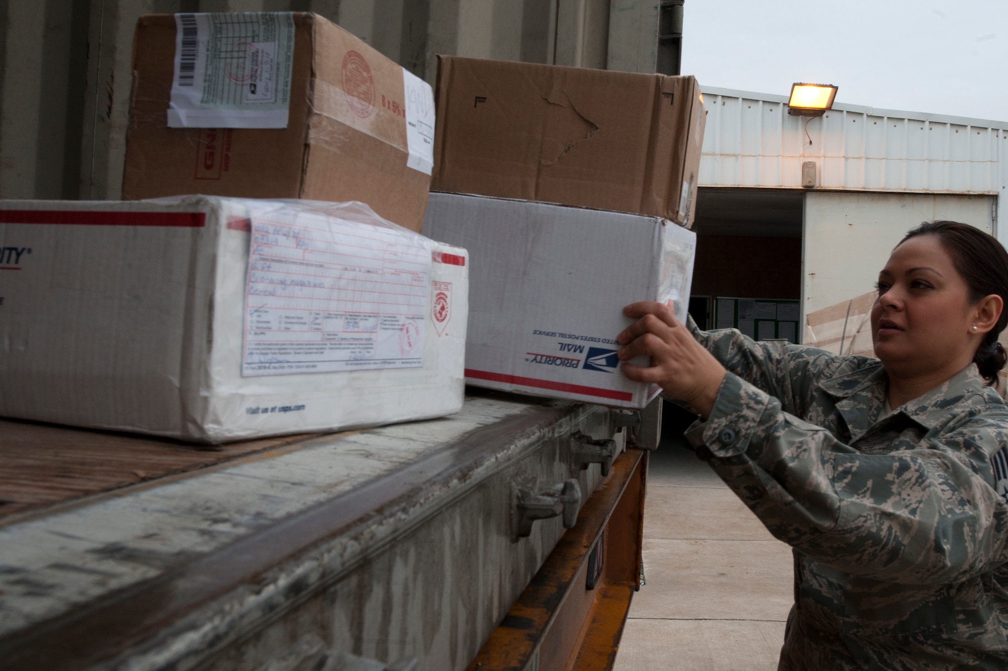 Senior Airman Jenniepher Barnaby, 332nd Expeditionary Communication Squadron postal clerk, off loads mail from a delivery truck at an undisclosed location in Southwest Asia, Jan. 13, 2012. Postal clerks handle all incoming and outgoing mail for the base. Barnaby is deployed from Ramstein Air Base, Germany.(U.S. Air Force photo by Staff Sgt. Joshua J. Garcia/Released)