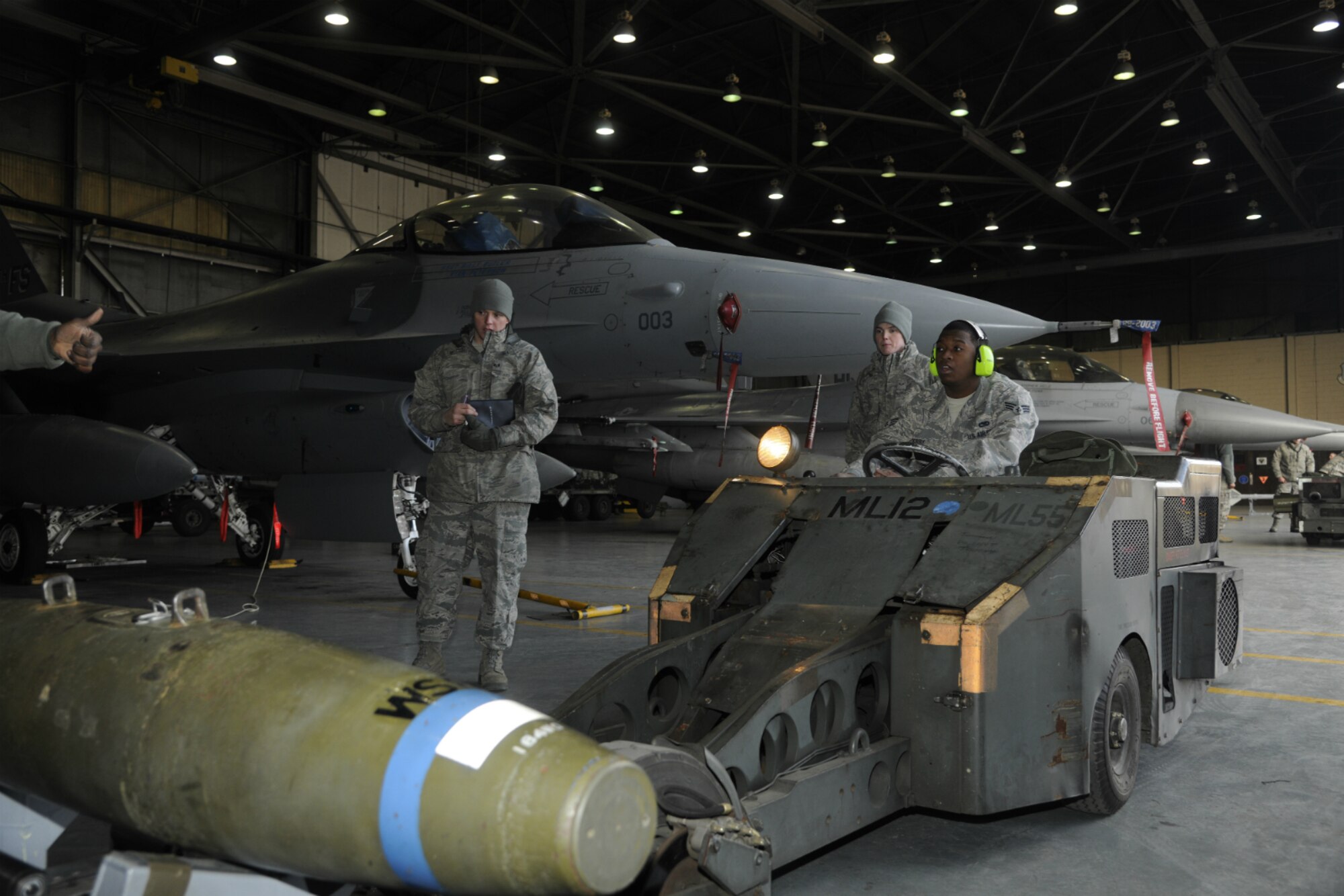 Senior Airman Demarcus Kirby, 35th Aircraft Maintenance Unit weapons load crew member, drives an MJ1 bomb lift-truck to pick a weapon up to be loaded on an F-16 Fighting Falcon during a peninsula weapons loading competition at Kunsan Air Base, Republic of Korea, Jan. 11, 2012. Each team raced against time loading training weapons on their respective F-16 Fighting Falcons trying to minimize discrepancies. The training of the teams improves job performance, but it also fosters teamwork and camaraderie. (U.S. Air Force photo by Staff Sgt. Rasheen A. Douglas/Released)