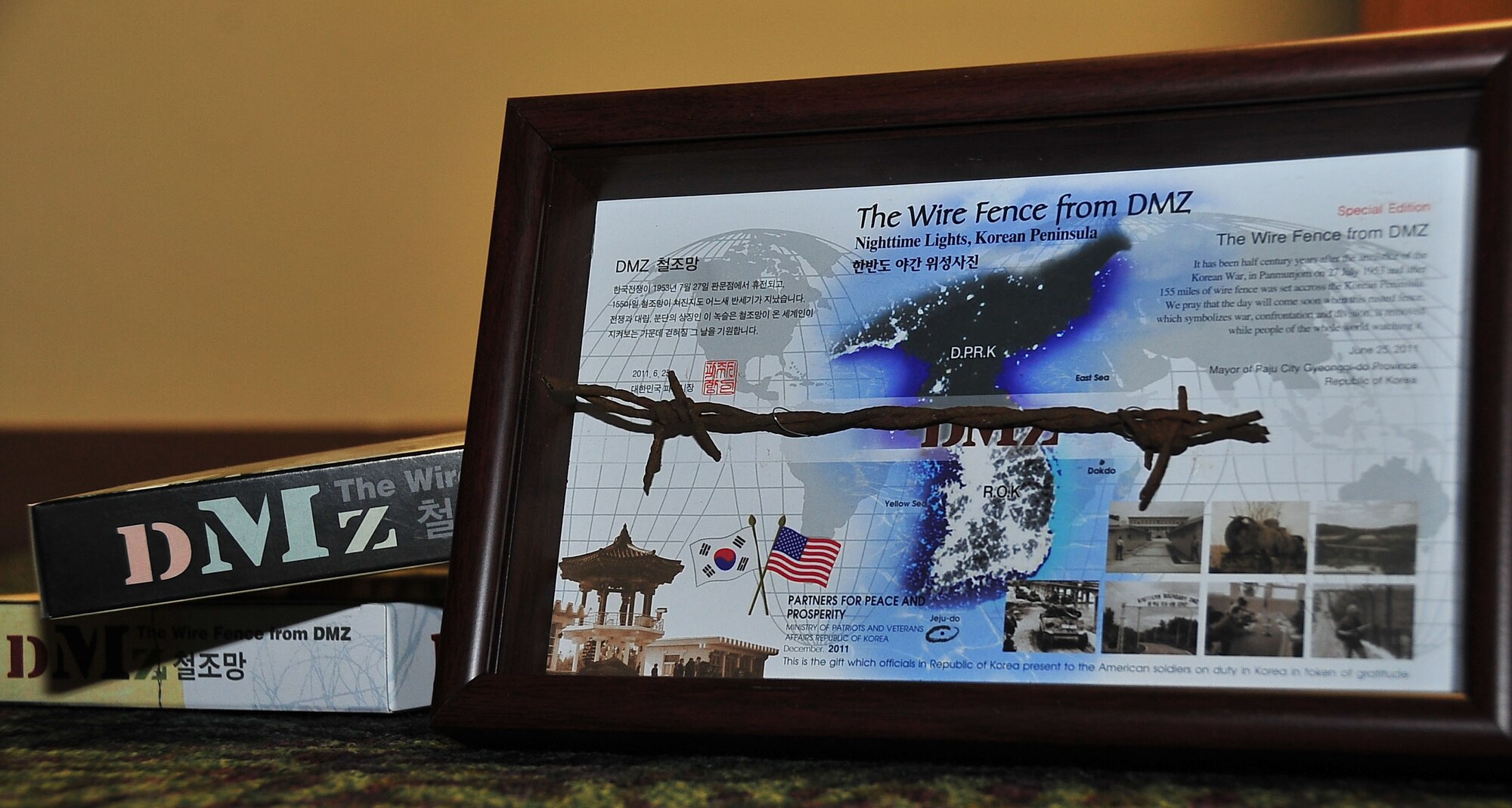 All service members stationed in South Korea received a special edition, framed portion of wire fence from the demilitarized zone that separates North and South Korea. Approximately 155 miles of fence was laid across the DMZ and symbolizes war and separation, but it’s also symbolic of hope that one day the fence could be removed and Korea would become a unified, peaceful nation, according to the statement on the gift. (U.S. Air Force photo/ Staff Sgt. Stefanie Torres)