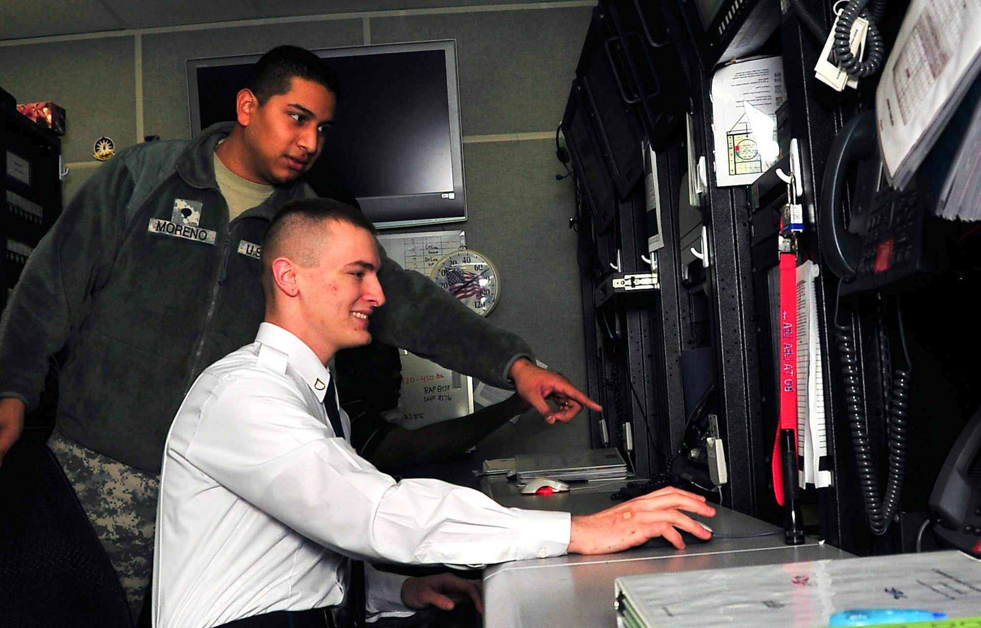 Spc. Carlos Moreno and Pfc. Anthony Rudd, 8th Army Early Warning Systems operators, work together in the 607th Air Operations Center after the two units merged together recently. The 8th Army Joint Interface Control Cell merged with the 607th Air Operations Center to streamline both organizations. (U.S. Air Force photo/Staff Sgt. Stefanie Torres)