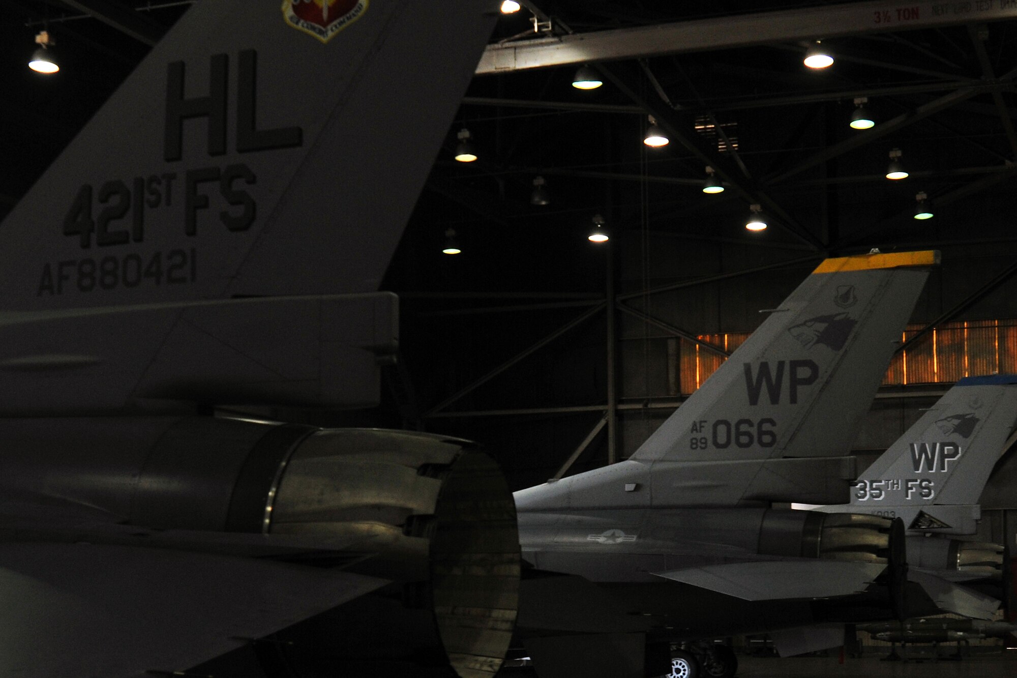 Three F-16 Fighting Falcons from the 421st Aircraft Maintenance Unit, 80th AMU and 35th AMU sit in a hangar during the 4th quarter 8th Maintenance Group peninsula weapons loading competition at Kunsan Air Base, Republic of Korea, Jan. 11, 2012. Each team raced against time loading training weapons on their respective F-16 Fighting Falcons trying to minimize discrepancies. (U.S. Air Force photo by Senior Airman Brittany Y. Auld/Released)