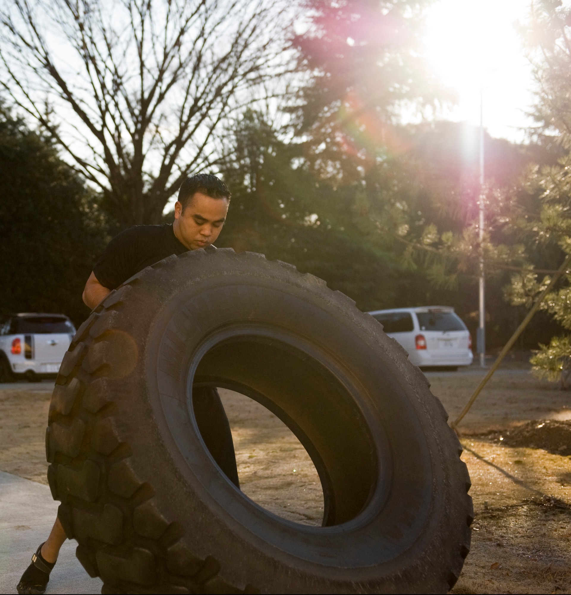 YOKOTA AIR BASE, Japan -- Tech. Sgt. Michael Peralta, 374th Force Support Squadron NCO in charge of fitness and sports, demonstrates a tire flip taught at the Samurai Fitness Center's Cross Training class at Yokota Air Base, Japan, Jan. 13, 2012. The class works on building up one's core strength and endurance to help Airmen with physical fitness and the Air Force's mandated physical training test. (U.S. Air Force photo/Airman 1st Class John D. Partlow)