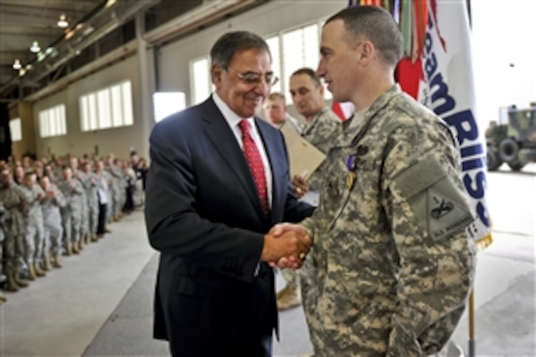 Defense Secretary Leon E. Panetta congratulates a soldier after awarding the Purple Heart to him during a visit with troops on Fort Bliss near El Paso, Texas, Jan. 12, 2012.