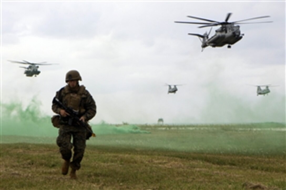 Sgt. Donald Christensen, an explosive ordnance disposal technician with Company C, Battalion Landing Team 1st Battalion, 4th Marines, 31st Marine Expeditionary Unit, moves into position as helicopters prepare to land during Marine Expeditionary Unit Exercise at Okinawa, Japan, on Jan. 12, 2012.  This training is a multi-week training exercise conducted prior to every 31st Marine Expeditionary Unit deployment.  