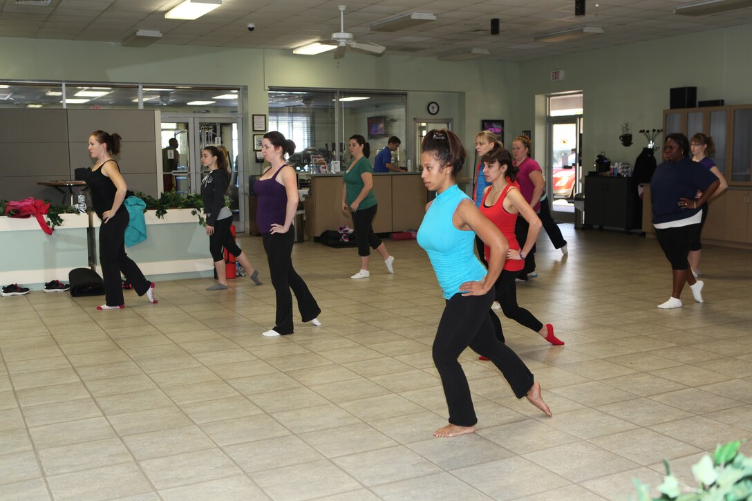 A row of people stretch their legs out in a ballet segment of  Midway Parks Community Centers Ballet Pilates Fusion class exercise in Midway Park, a housing community of Marine Corps Base Camp Lejeune, Jan. 14. The class has 3 instructors, including  Christina Hardy, who has an extensive background in dance.