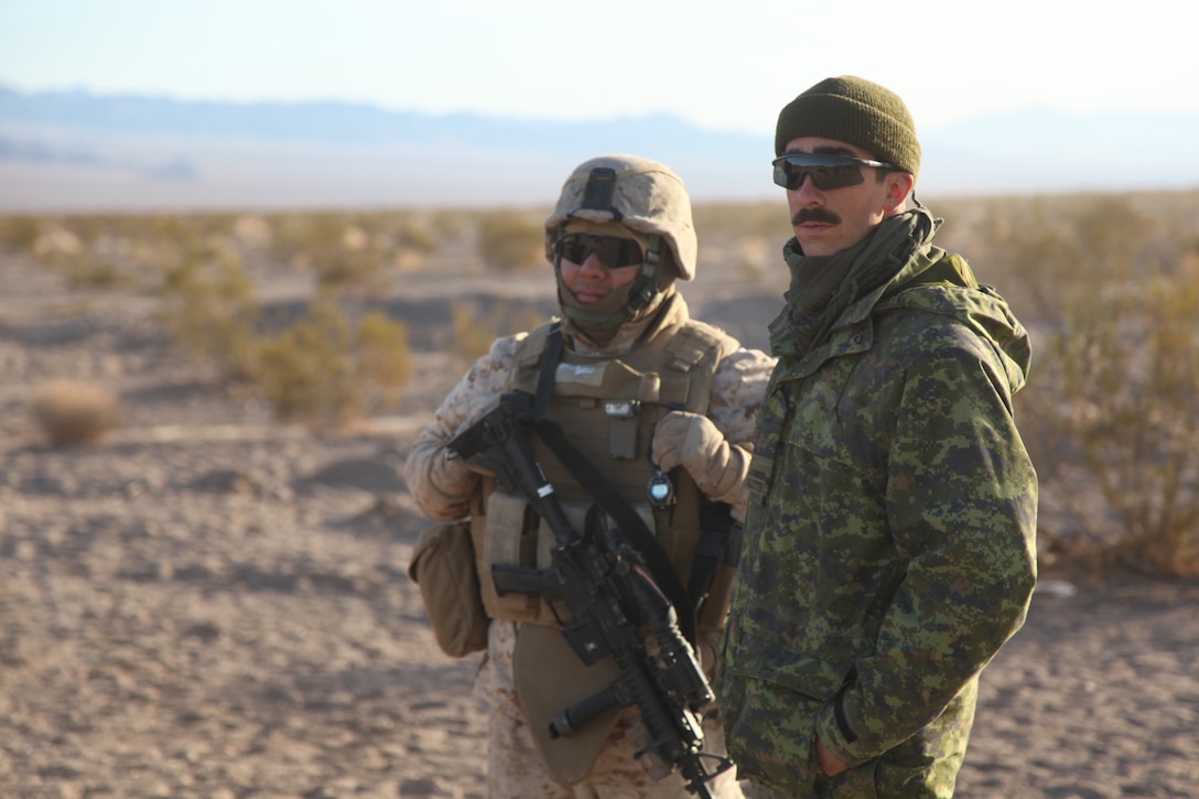 1st Lt. Mark Palland, Squadron B, 12th Regiment Blinde du Canada, and U. S. Marine Staff Sgt. Mauricio Ramirez, 3rd Light Armored Reconnaissance Battalion, speak about their day’s exercise Jan. 14.::r::::n::