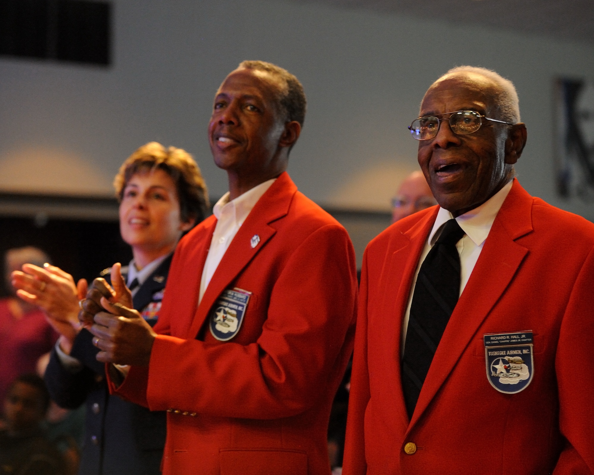 From right, retired U.S. Air Force Chief Master Sgt. Richard R. Hall, Jr., a member of the Tuskegee Airmen, retired U.S. Air Force Lt. Col. Montoria Hubbard, the Tuskegee Airmen Gen. Daniel "Chappie" James chapter president, and U.S. Air Force Col. Gina Humble, 11th Operations Group commander at Joint Base Anacostia-Bolling in Washington, D.C., sing the Air Force song during a concert at The First Academy Faith Hall in Orlando, Fla., Jan. 14, 2011.  The U.S. Air Force Band Ceremonial Brass honored Tuskegee Airmen, the first African American military aviators in the U.S. armed forces, during their performance, playing a new work entitle "Red Tail Skirmish."  U.S. Air Force photo by Master Sgt. Adam M. Stump/Released.