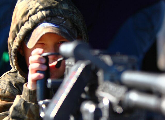 Chase Thomas, a local citizen from the Farmville, Va., area, looks down the barrel of an M-240 Medium Machine Gun that was mounted on a UH-1 Huey helicopter as part of a static display during the Marine Corps Community Day at Farmville Municipal Airport Jan. 14, 2012. The 24th MEU organized the event as part of their Realistic Urban Training exercise (RUT) to thank the community and highlight the capabilities of the Marine Air Ground Task Force. The RUT exercise is scheduled from Jan. 5-20, and is meant to allow the Marines to conduct off-base training near the town of Farmville to prepare for their upcoming deployment.