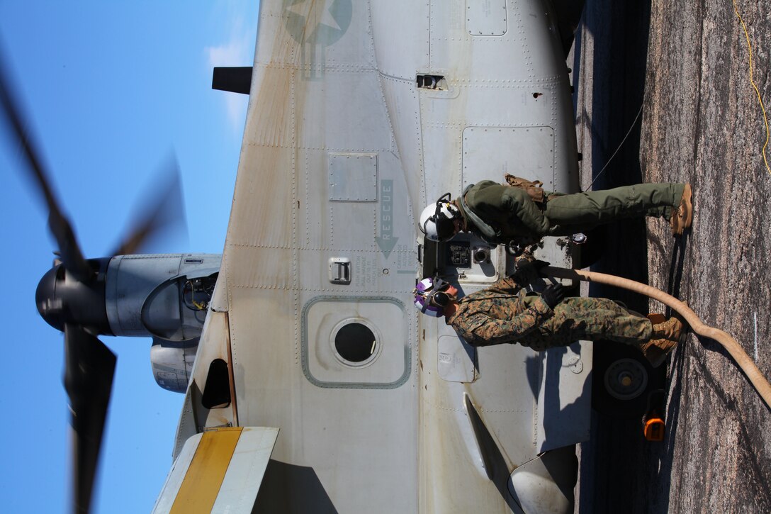 (Left) Lance Cpl. Nicholas Verdisco, a bulk fuel specialist with Marine Medium Tiltrotor Squadron VMM-261 (Reinforced), 24th Marine Expeditionary Unit, refuels an MV-22 Osprey with a Helicopter Expedient Refueling System, here, Jan. 14, 2012. The Marines refueled the aircraft to support a simulated airfield seizure at Farmville Municipal Airport, which is part of Realistic Urban Training (RUT) exercise scheduled Jan. 5-20. RUT focuses on conducting off-base missions near the town of Farmville, Va., to prepare for the various operations they may conduct during their upcoming deployment.