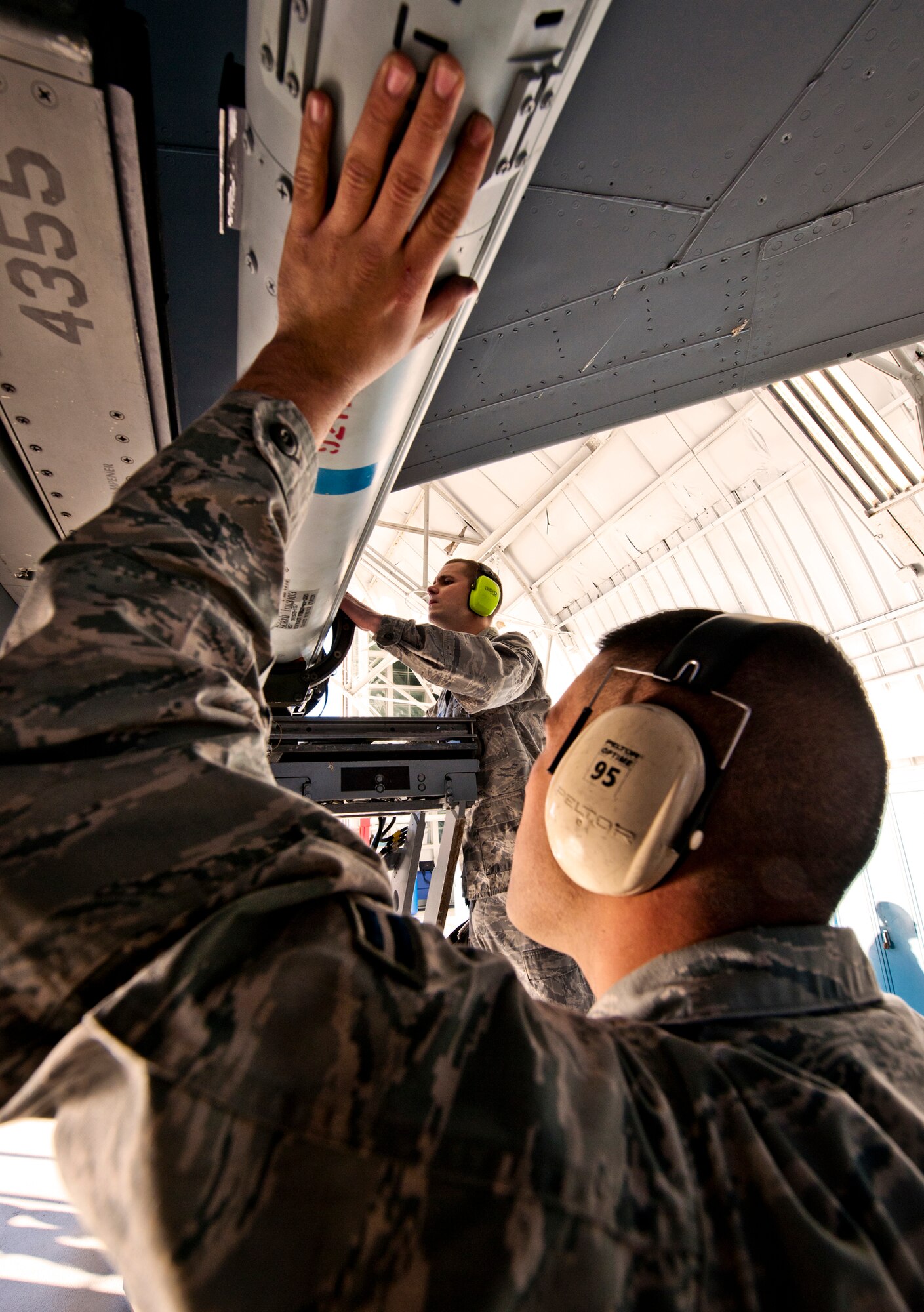 Staff Sgt. Kenneth Merritt, a 46th Aircraft Maintenance Squadron crew leader, checks the placement of the AIM-9 while Airman 1st Class Christopher Rose keeps the weapon still Jan. 13 during the 46th Maintenance Group's year-end weapons load competition at Eglin Air Force Base, Fla.  The best of the best from 46th AMXS met to load a Joint Direct Attack Munition and AIM-9 and a small diameter bomb onto an F-15. The winners will be announced at the 46th MXG annual awards banquet in March. (U.S. Air Force photo/Samuel King Jr.) 
