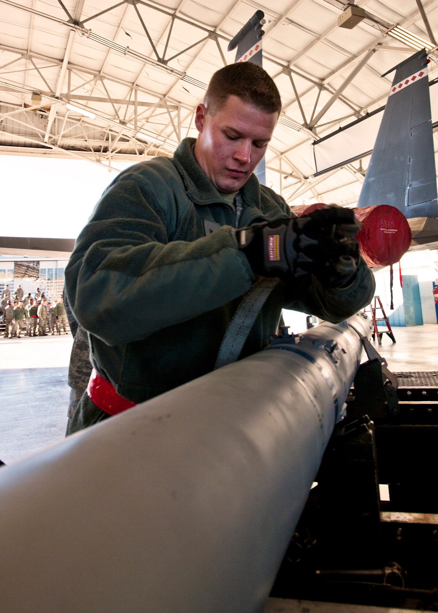 Airman 1st Class Mark Blinn, of the 46th Aircraft Maintenance Squadron, removes the straps from the AIM-9 Jan. 13 during the 46th Maintenance Group's year-end weapons load competition at Eglin Air Force Base, Fla.  The best of the best from 46th AMXS met to load a Joint Direct Attack Munition and AIM-9 and a small diameter bomb onto an F-15. The winners will be announced at the 46th MXG annual awards banquet in March. (U.S. Air Force photo/Samuel King Jr.) 
