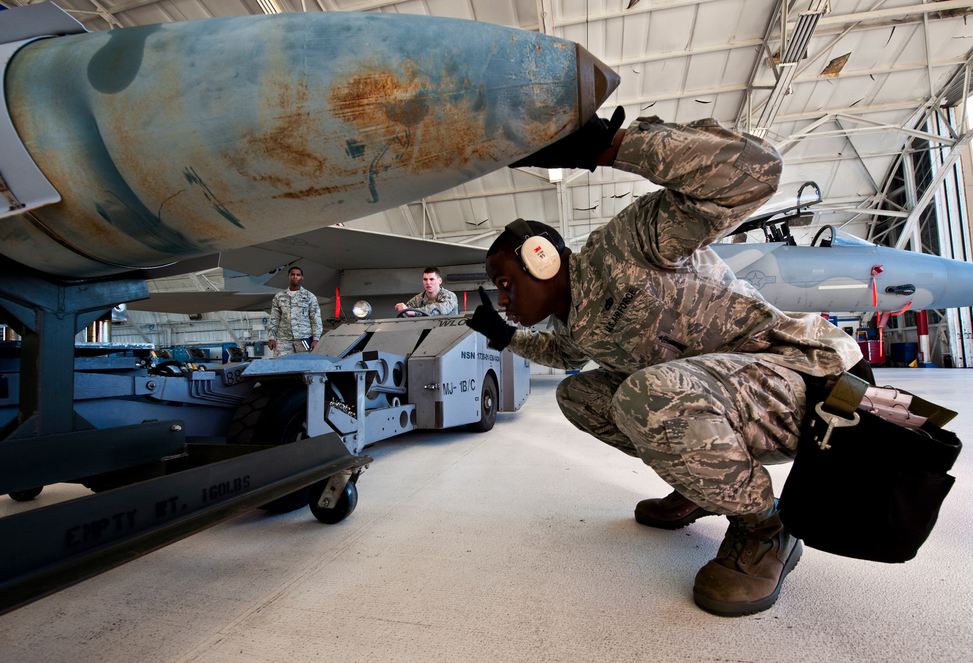 Staff Sgt. Anthony Childers, a 46th Aircraft Maintenance Squadron crew leader, guides the loader toward the Joint Direct Attack Munition during the 46th Maintenance Group’s year-end weapons load competition at Eglin Air Force Base, Fla., Jan 13. The best of the best from 46th AMXS met to load a JDAM and AIM-9 and a small diameter bomb onto an F-15. The winners will be announced at the 46th MXG annual awards banquet in March. (U.S. Air Force photo/Samuel King Jr.)