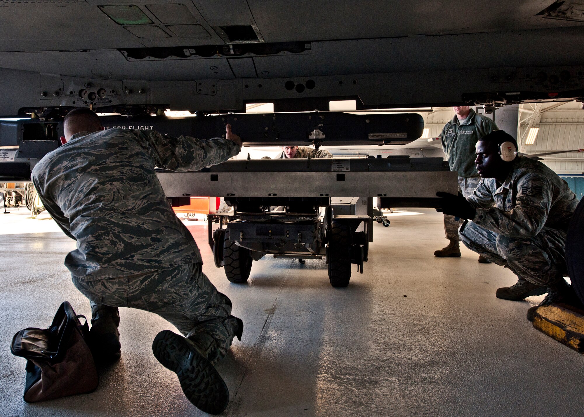 It takes all three 46th Aircraft Maintenance Squadron load crew members to position the small diameter bomb on the F-15 during the 46th Maintenance Group’s year-end weapons load competition at Eglin Air Force Base, Fla., Jan 13. The best of the best from 46th AMXS met to load a Joint Direct Attack Munition and AIM-9 and a SDB onto an F-15. The winners will be announced at the 46th MXG annual awards banquet in March. (U.S. Air Force photo/Samuel King Jr.)