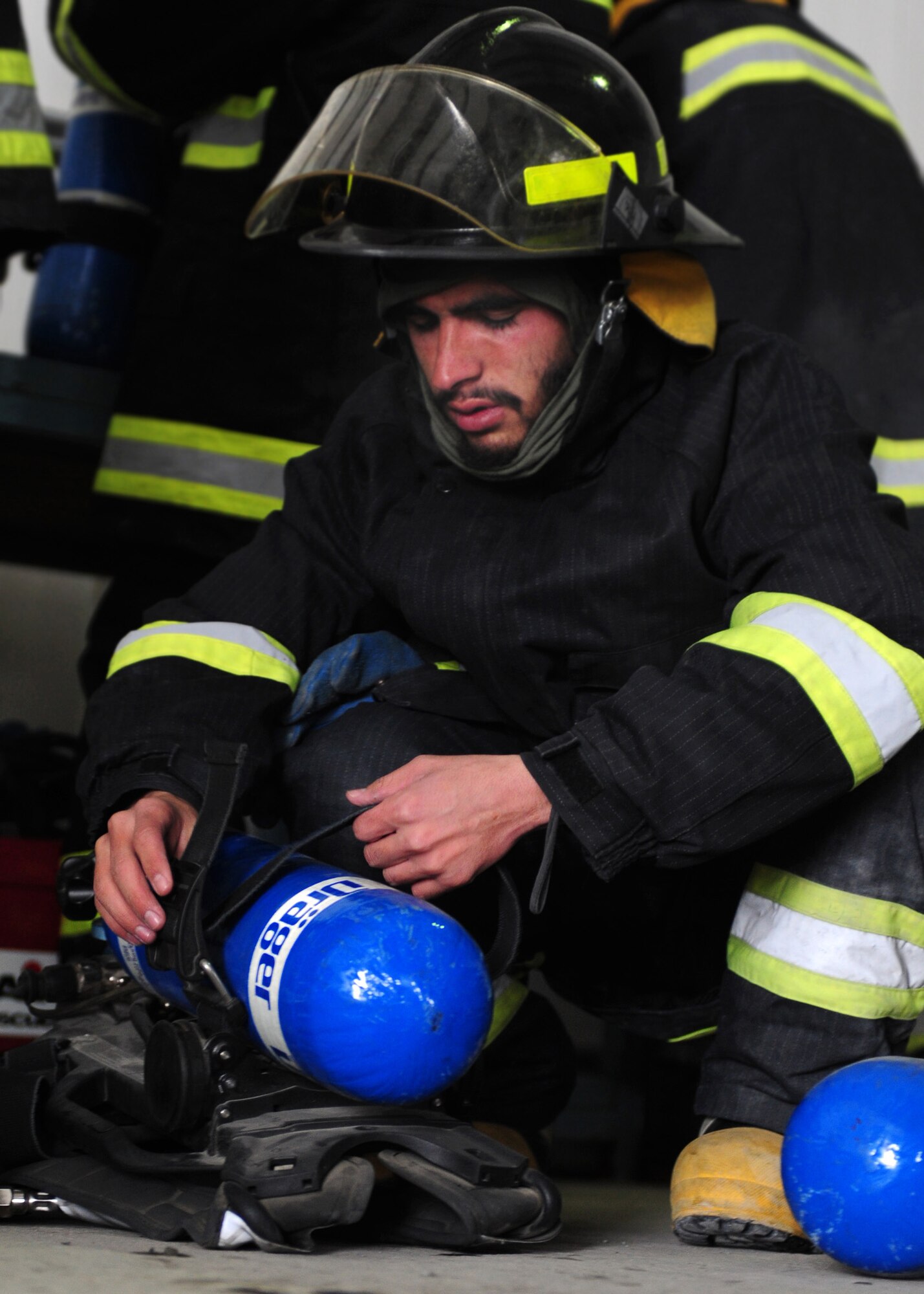 An Afghan air force firefighter assembles his personal protective equipment prior to a live fire exercise at the Air University Fire Academy, Kabul International Airport, Jan. 15, 2012. The firefighters participated in a three day course that included training on controlled fires, donning of protective equipment and safety procedures used in a controlled environment under the supervision of U.S. Air Force advisors.  (Photo by Staff Sgt. Nadine Y. Barclay) 