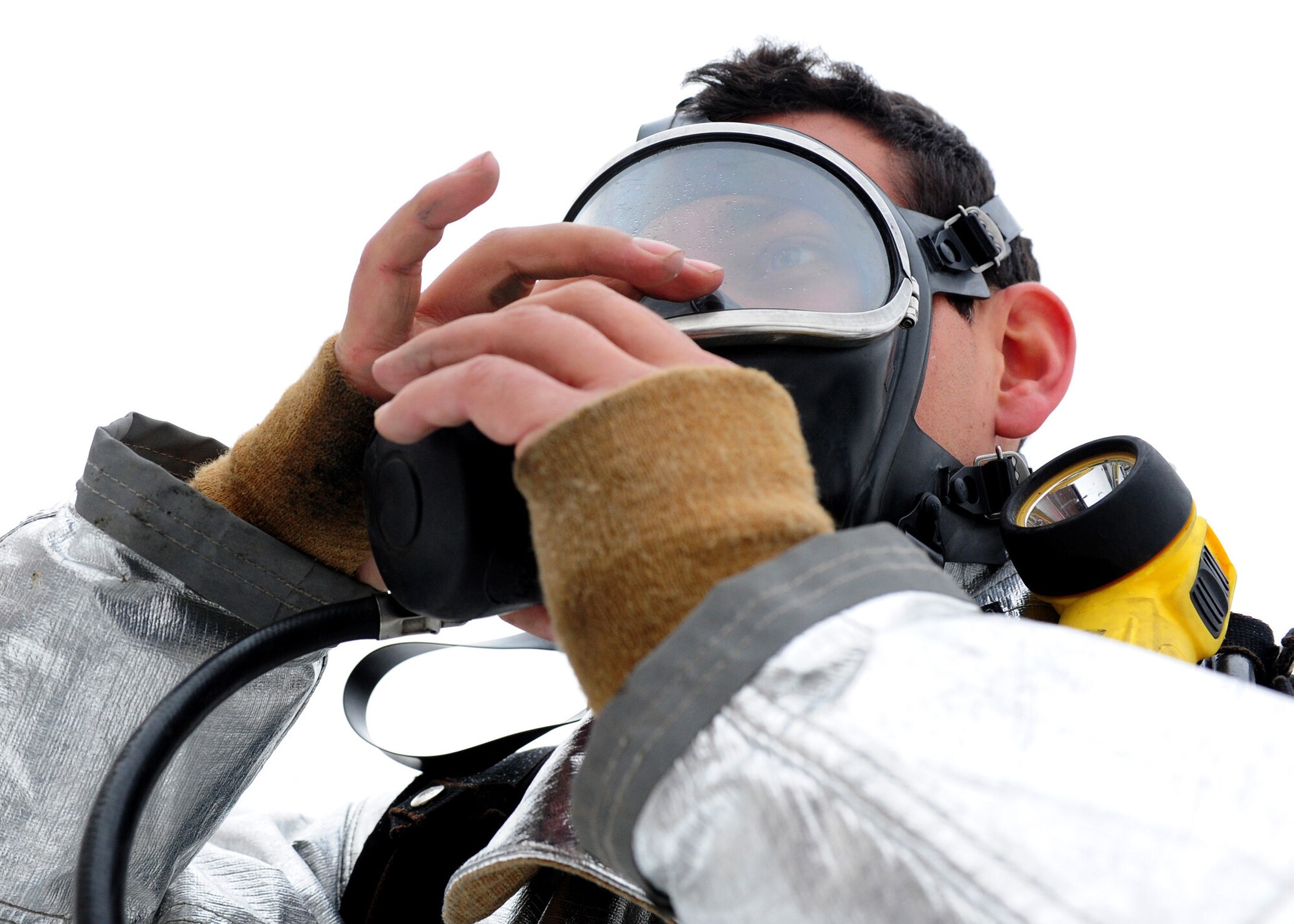 Senior Airman Paul Hartmire, an advisor with the 439th Air Expeditionary Advisory Squadron, adjusts his oxygen mask while suiting up for a live fire training exercise at Kabul International Airport, Jan. 15, 2012. Hartmire is currently deployed from Aviano Air Base, Italy to provide Afghan army and air force firefighters with advisory training about proper fire fighting techniques. (Photo by Staff Sgt. Nadine Y. Barclay)