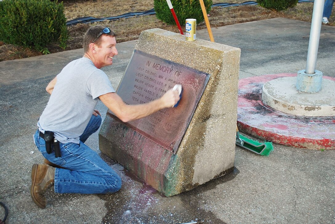 Air Force Reserve Master Sgt. Michael Weaver from the 919th Communications Squadron polishes a weather-tarnished memorial plaque during a recent volunteer project at Duke Field, Fla.   Weaver, representing the Top 3 Association, teamed with a group of 919th Force Support Squadron volunteers who worked to beautify the base’s centrally located memorial area with a host of landscaping and maintenance projects.  (Courtesy photo) 