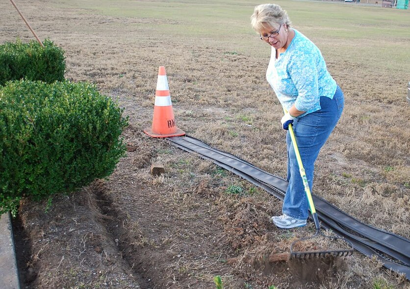 Mitzi Cochran, a civilian employee from the 919th Force Support Squadron, rakes debris during a recent volunteer project at Duke Field, Fla.   Cochran was among a group of FSS and Top 3 Association volunteers who worked to beautify the base’s centrally located memorial area with a host of landscaping and maintenance projects. (Courtesy photo) 