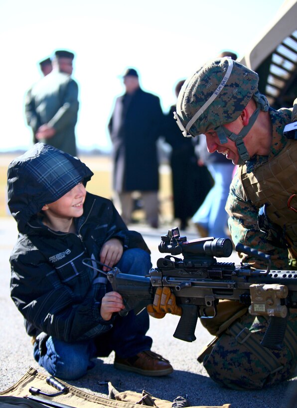 Lance Cpl. Billy Kimball, an assistant team leader with Bravo Company, Battalion Landing Team 1st Battalion, 2nd Marine Regiment, 24th Marine Expeditionary Unit, shows an M-249 Squad Automatic Weapon to Justin Kapuscinski, a local citizen of the Farmville, Va. area during the Marine Corps Community Day at Farmville Municipal Airport Jan. 14, 2012. The 24th MEU organized the event as part of their Realistic Urban Training exercise (RUT) to thank the community and highlight the capabilities of the Marine Air Ground Task Force. The RUT exercise is scheduled from Jan. 5-20, and is meant to allow the Marines to conduct off-base training near the town of Farmville to prepare for their upcoming deployment.