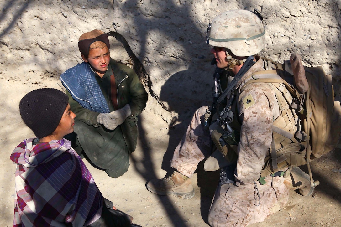 A Marine with I Co., 3rd Battalion, 7th Marine Regiment, talks with children from a small village near Sangin, Afghanistan, during a routine security Patrol. The Marines of I Co. maintain a good relationship with the local villagers by conducting security patrols along with members of the Afghan National Army.