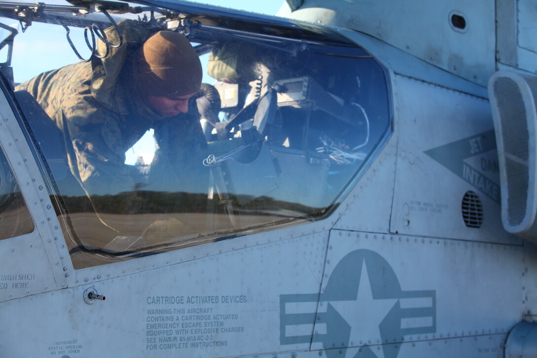 Cpl. Charles Ulrich, a flightline mechanic with Marine Medium Tiltrotor Squadron VMM-261 (Reinforced), 24th Marine Expeditionary Unit, crawls into the cockpit of a AH-1 Super Cobra helicopter for a pre-flight inspection Jan. 13, 2012, here. The Sparta, N.J., native said he joined the Marine Corps because he wanted to work on helicopters and be a Marine like his grandfather. The unit's upcoming deployment will be the first time the Iraq war veteran will deploy with a MEU.