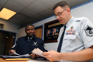 U. S. Air Force Master Sgt. Kelly Bacon, 633rd Civil Engineer Squadron NCO-in charge of Command Support Staff, receives Basic Allowance for Housing assistance from Master Sgt. Keith Munroe, 633 Comptroller Squadron Financial Services flight chief, at Langley Air Force Base Va., Jan. 10, 2012. The 633rd CPTS provides accounting, finance, budget and cost analysis for the 633rd Air Base Wing and over 30 associate units, including Headquarters Air Combat Command. (U.S. Air Force photo by Staff Sgt. Jeff Nevison/Released)