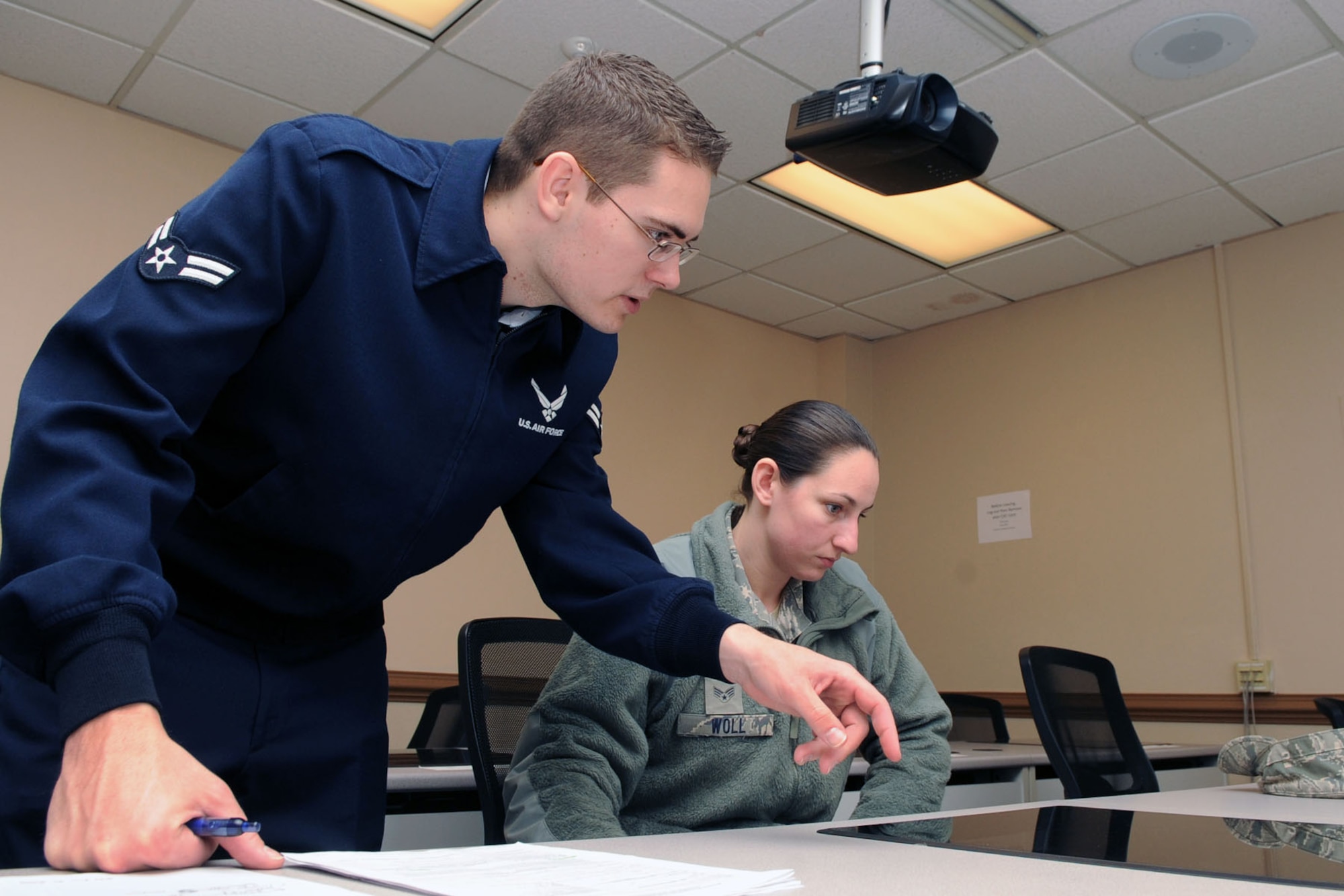 U. S. Air Force Airman 1st Class Andrew Neikirk, 633rd Comptroller Squadron travel technician, assists Senior Airman Jessica Woll, 30th Intelligence Squadron imagery analyst, with questions about Basic Allowance for Housing at Langley Air Force Base Va., Jan. 10, 2012. The 633rd CPTS Finance Customer Service Office uses the Permanent Change of Station In-Processing System which allows personnel to file their own PCS vouchers from start to finish without a middleman. (U.S. Air Force photo by Staff Sgt. Jeff Nevison/Released)