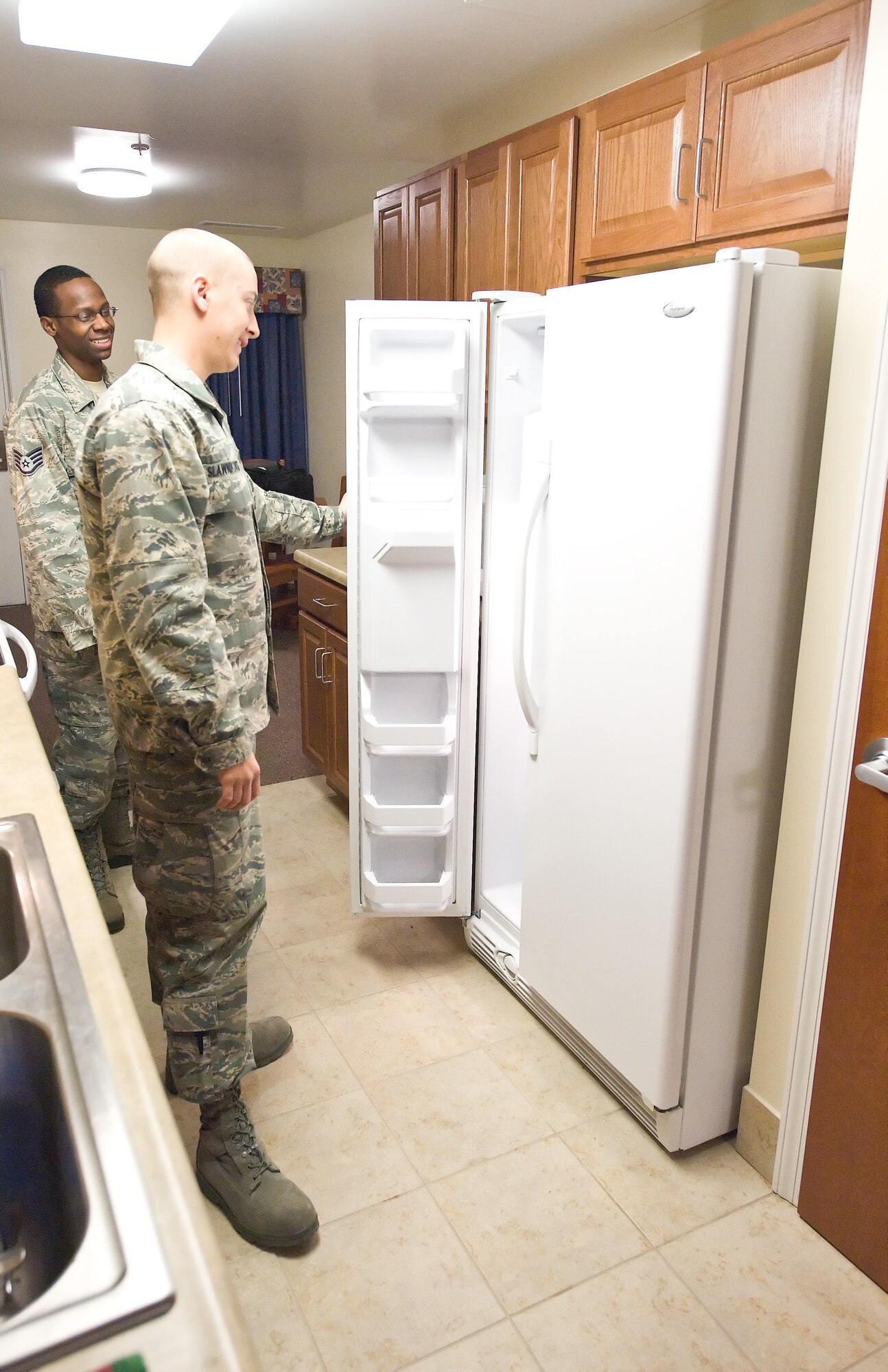 Staff Sgt. Michael Jones, an Airmen Dormitory Leader with the 436th Civil Engineer Squadron, and Airman Basic Ozzie Slawnikowski, a member of the Detachment 3, 373rd Training Squadron, inspect a refrigerator at Dormitory 414 at Dover Air Force Base, Del. (U.S. Air Force photo by Roland Balik)