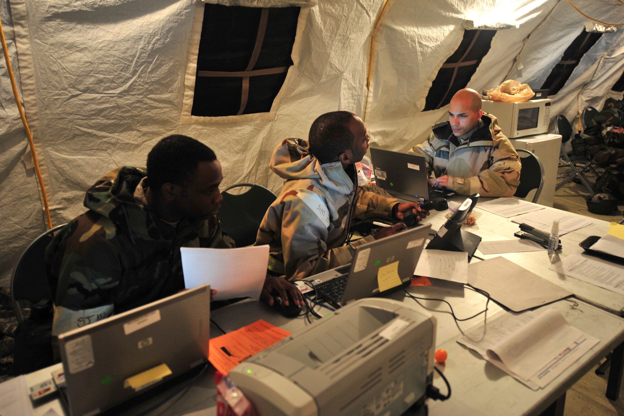 U.S. Air Force Senior Airmen Roman Bethea, left, Tech. Sgt. Bernard Smith, center, and Staff Sgt. Eduardo Peguero, 23rd Force Support Squadron, collect accountability information during an operational readiness exercise at Moody Air Force Base, Ga., Jan. 11, 2012. The Airmen worked as personnel support for contingency operations team members whose primary mission was to provide force accountability, casualty reporting and sustainment functions to assist in managing the deployed force. (U.S. Air Force photo by Staff Sgt. Stephanie Mancha/Released)