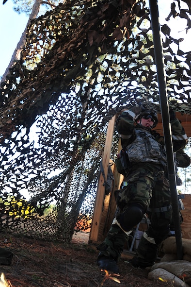 U.S. Air Force Airman Jordan Patterson, 23rd Security Forces Squadron fire team member, fixes the camouflage netting of a defensive fight position during an operational readiness exercise at Moody Air Force Base, Ga., Jan. 11, 2012. The purpose of the camouflage netting is to provide concealment for Airmen. (U.S. Air Force photo by Staff Sgt. Stephanie Mancha/Released)