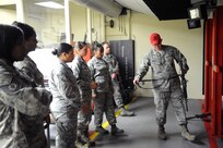 Staff Sgt. Joshua Clements (right), 902nd Security Forces Squadron, demonstrates how to use a sling during M-4 carbine qualification training Jan. 11. Training was held at the small arms range on Joint Base San Antonio-Randolph. (U.S. Air Force photo/Rich McFadden) (released)