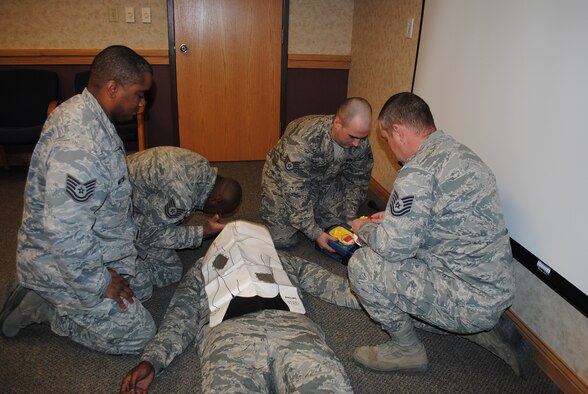 (From left) Tech. Sgt. Damien Mitchell, airfields with the 819th RED HORSE Squadron; Tech. Sgt. Terry McNeil, electrician with the 819th RHS; Staff Sgt. Sean Bilodeau, heavy equipment operator with the 819th RHS; and Tech. Sgt. Christopher Pierce, heavy equipment operator with the 819th RHS, practice CPR and operating an automated external defibrillator on Senior Airman Reggie Manning, material controller with the 341st Logistics Readiness Squadron. These four sergeants from the 819th RHS recently used these techniques to save the life of a Team Malmstrom member.  (U.S. Air Force photo/Airman 1st Class Katrina Heikkinen)