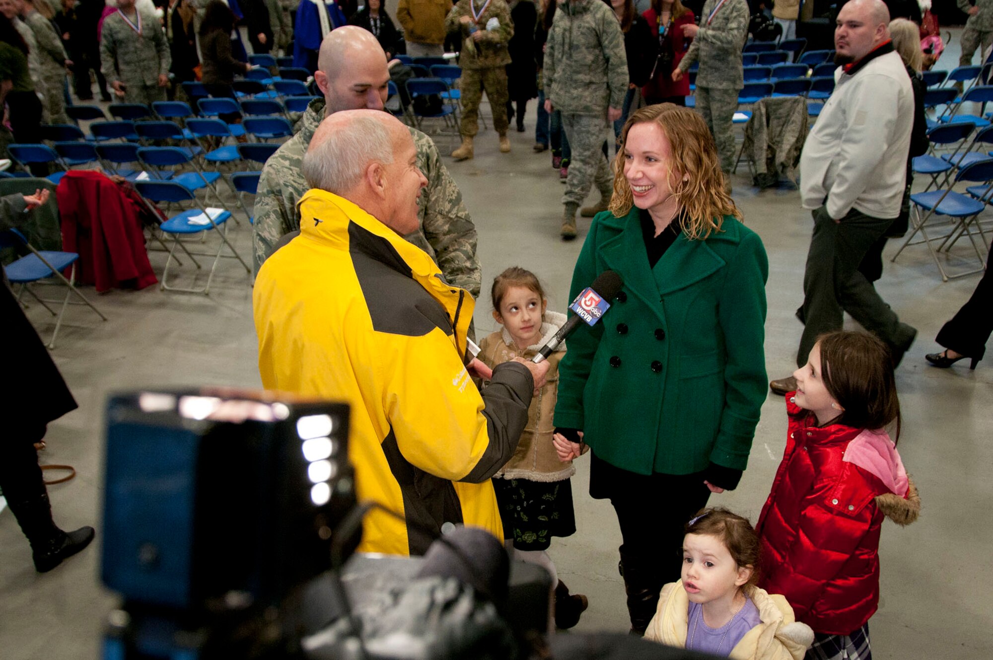 HANSCOM AIR FORCE BASE, Mass. – Laura King, with her husband, Capt. Timothy King, and daughters (from left to right) Holly, Lily and Daisy, is interviewed by Jack Harper from WCVB-TV, after a homecoming celebration Jan. 12. Mrs. King was interviewed about how her life was affected while her husband was deployed. (U.S. Air Force photo by Mark Wyatt)