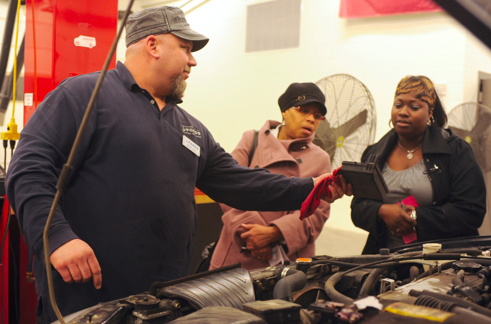 Timothy Tyree, left, an automotive mechanic at the 436th Force Support Squadron Arts and Crafts Center, shows spouses how to read a fuse box cover during an automotive class Jan. 12, 2012, at Dover Air Force Base, Del. The goal of the class was to help new drivers better identify problems with their vehicles by teaching them basic maintenance and part identification. (U.S. Air Force photo by Senior Airman Matthew Hubby)