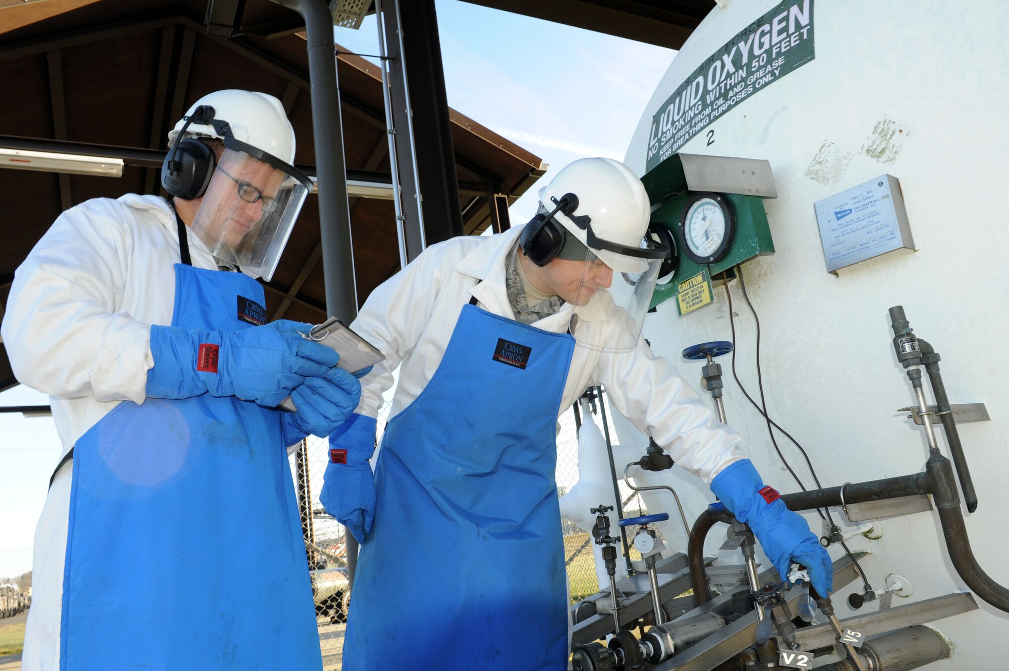 SPANGDAHLEM AIR BASE, Germany – Airman 1st Class Kyle Coates, 52nd Logistics Readiness Squadron hydrant operator, reads a checklist while Staff Sgt. Celso Velez, NCO in charge of cryogenics, turns the valve on the liquid oxygen tank to build pressure during the issuing of oxygen here Jan. 17. The cryogenics shop supplies the cargo planes with oxygen ensuring the planes are mission ready. (U.S. Air Force photo / Senior Airman Christopher Toon)